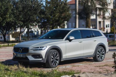 Yana, Türkiye - 27 Ocak 2022: Gümüş Volvo V90 bir yaz günü bir binanın, çitin, parkın arka planına karşı sokağa park ediyor