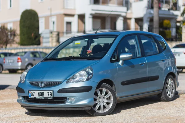 Yana, Türkiye - 28 Ocak 2022: Mavi Honda Jazz sıcak bir günde bir binanın zeminine park etti.