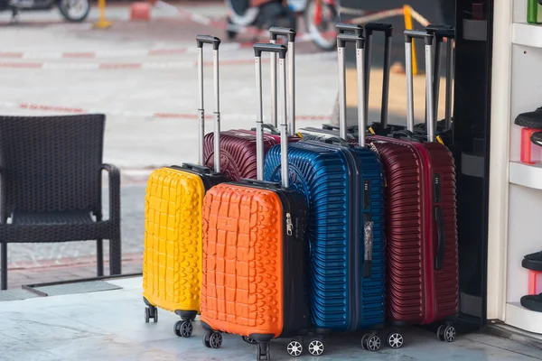 明るい青 黄色とオレンジのスーツケースの行を拡張ハンドルと異なるサイズは 店の前に販売されています — ストック写真