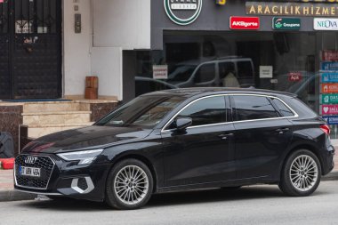 Yana, Türkiye - 27 Ocak 2022: Siyah Audi A3 bir yaz günü bir binanın, dükkanın arka planına karşı sokağa park ediyor