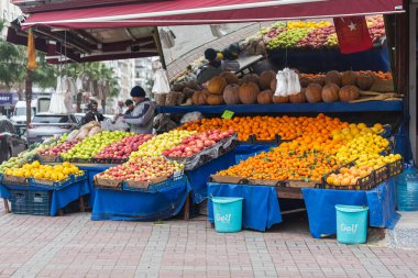 Yan, Türkiye - 29 Ocak 2022: Erkek satıcı pazarda meyve satıyor. Meyve dükkanı elmaları, kavun, mandalina, podidory