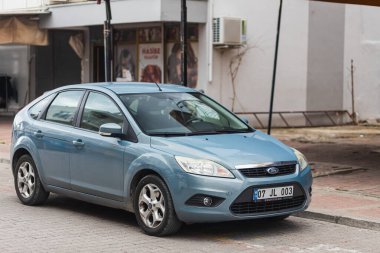 Taraf, Türkiye - 29 Ocak 2022: Mavi Ford Focus sıcak bir yaz gününde binanın zeminine karşı sokağa park etti