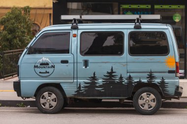 Yana, Türkiye - 27 Ocak 2022: Mavi Suzuki Super Carry sıcak bir günde bir dükkanın arka planına park etti