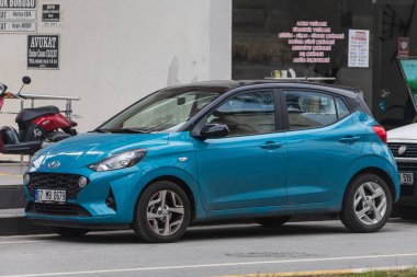 Yana, Türkiye - 27 Ocak 2022: Mavi Hyundai i10 bir yaz günü bir dükkanın arka planına park ediyor.