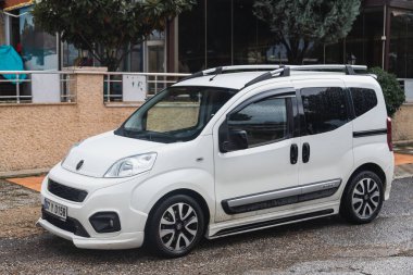Yana, Türkiye - 30 Ocak 2022: Beyaz Fiat Fiorino bir yaz günü bir çitin arkasına park ediyor.