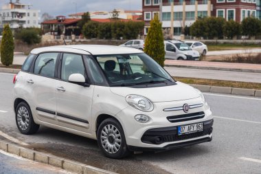 Kenar: Türkiye 01 Şubat 2022: Sıcak bir yaz gününde şehir trafiğine karşı sokağa park edilmiş beyaz Fiat 500  