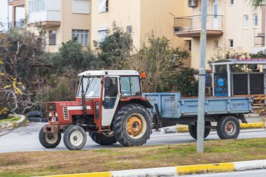 Taraf; Türkiye 01 Şubat 2022: Erkek işçi traktör sürücüsü römork kullanıyor 