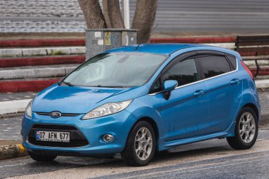 Yana, Türkiye - 02 Şubat 2022: Mavi Ford Fiesta sıcak bir sonbahar gününde sokağa park edildi 