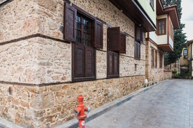 Ahşap pencereli ve panjurlu taş bir evin duvarına yakın çekim. Eski Avrupa mimarisi