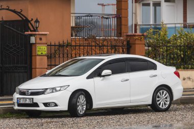 Taraf, Türkiye - 02 Şubat 2022: Beyaz Honda Civic sıcak bir günde bir bina, park, çit zeminine karşı sokağa park etti