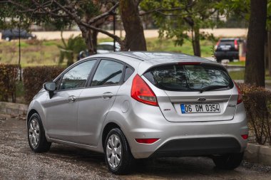Yana, Türkiye - 02 Şubat 2022: Gümüş Ford Fiesta sıcak bir günde bir binanın, parkın, çitin zeminine park etti.