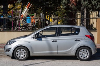 Yan, Türkiye 2 Şubat 2022: Gümüş rengi Hyundai i20 bir yaz günü bir parkın arka planına park ediyor 