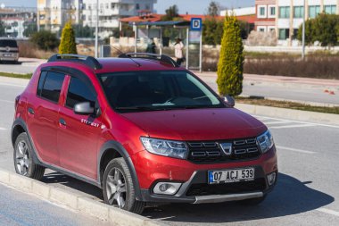 Yan, Türkiye 6 Şubat 2022: Kırmızı Dacia Sandero Stepway sıcak bir yaz gününde yola park etti 