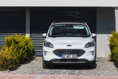 Yan, Türkiye - 22 Ocak 2022: Beyaz Ford Kuga, sıcak bir günde bir evin arka planına, bahçeye park etti.