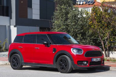 Yan, Türkiye 6 Şubat 2022: Kırmızı Mini Vatandaş sıcak bir yaz gününde bir binanın zeminine, ağaçlara karşı sokağa park etti 