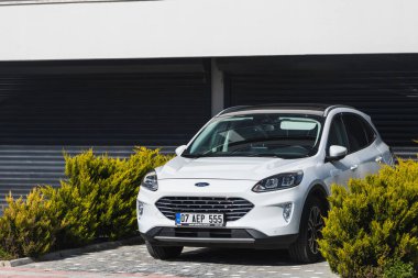 Yan, Türkiye - 22 Ocak 2022: Beyaz Ford Kuga, sıcak bir günde bir evin arka planına, bahçeye park etti.