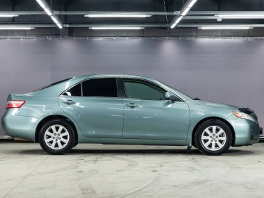 Novosibirsk, Rusya - 10 Şubat 2022: Mavi Toyota Camry, yan görüş. Otoparkta popüler bir sedan.   
