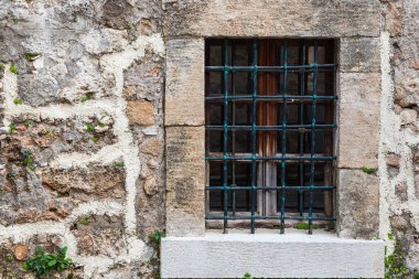 Eski bir evin camında siyah, sahte bir çitin yakın çekimi.