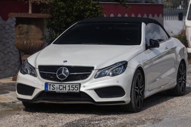 Yana, Türkiye - 13 Şubat 2022: Sıcak bir günde beyaz Mercedes-Benz E-sınıfı sokağa park edildi 