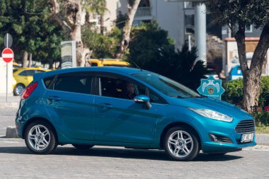 Yan, Türkiye - 16 Şubat 2022: Gümüş rengi Ford Fiesta, sıcak bir günde bir bina, park, çit zeminine karşı sokağa park etti