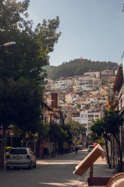 Alanya, Türkiye - 16 Şubat 2022: Tropikal bir ülkenin yerleşim bölgesi, güneşte güneşlenen su varilleri ve Türk bayrağı ile benzer evler