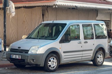 Yan, Türkiye 16 Şubat 2022: Gümüş rengi Ford Tourneo Connect, sıcak bir yaz gününde caddeye park etti. 