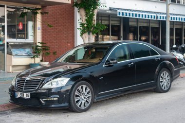 Yan, Türkiye 16 Şubat 2022: Siyah Mercedes S-Sınıfı Maybach sıcak bir sonbahar gününde sokakta hızlı sürüyor 