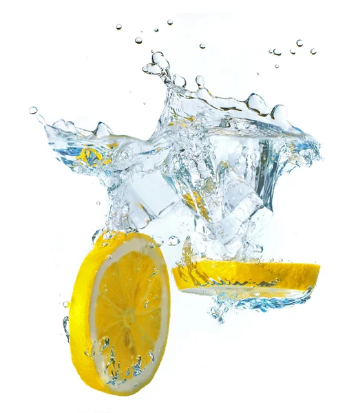 Лимонные ломтики и кубики льда брызгают водой — стоковое фото