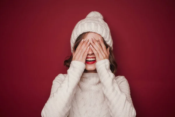 Fröhlich lächelnde Frau im Pullover verhüllt ihre Augen lizenzfreie Stockfotos