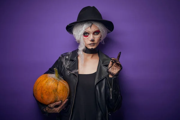 Fröhliche junge Frau im Halloween-Kostüm mit Kürbis lizenzfreie Stockfotos