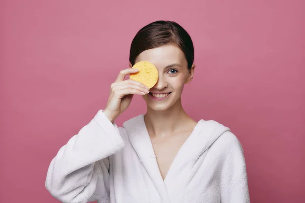 Jovem bela menina sorridente detém esponja de limpeza Imagens Royalty-Free