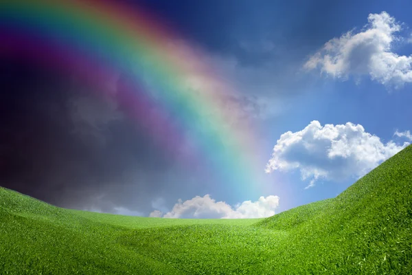 Regenbogen über grünen Hügeln — Stockfoto