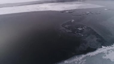 Dondurucu Baykal. Baykal kış uykusuna yatar. Baikalsk şehrinin buzlu kıyıları ve dağların manzarası. Doğal arka plan. Mevsimleri değiştiriyorum. Bir İHA 'dan ateş etmek.