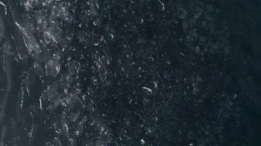 Dondurucu Baykal. Baykal kış uykusuna yatar. Baikalsk şehrinin buzlu kıyıları ve dağların manzarası. Doğal arka plan. Mevsimleri değiştiriyorum. Bir İHA 'dan ateş etmek.