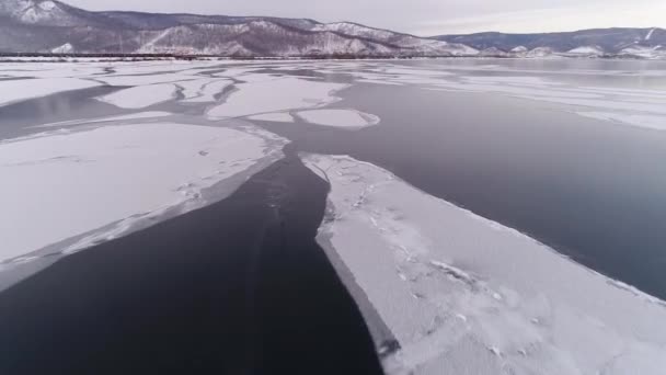 バイカルを解放する バイカルは冬眠に入る 山の景色を望むバイカルスク市の氷の海岸 自然な背景 季節が変わる 無人機からの銃撃 — ストック動画