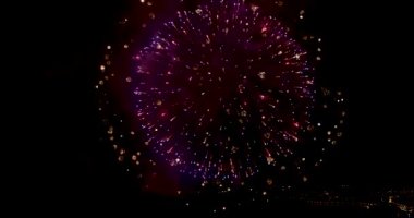 Şehrin gece gökyüzü üzerinde havai fişekler. İHA 'dan yakın çekim. 4K video.