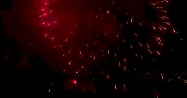 Şehrin gece gökyüzü üzerinde havai fişekler. İHA 'dan yakın çekim. 4K video.