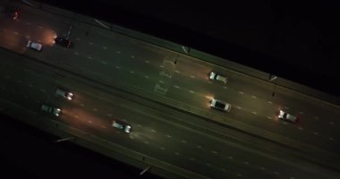 Gece şehri. Arabalar köprüden geçiyor. Bir İHA 'dan ateş etmek. Yukarıdan görüntüle.