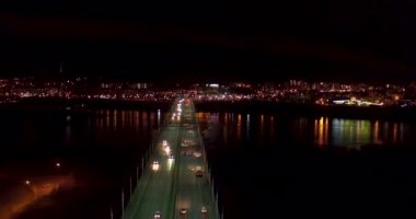 Gece şehri. Arabalar köprüden geçiyor. Bir İHA 'dan ateş etmek. Yukarıdan görüntüle.