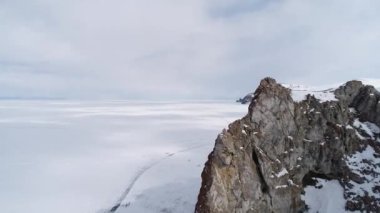Donmuş Baykal Gölü. Olkhon Adası güzel Üç Kardeş kayalıklarıyla çevrilidir. Muhteşem kış manzarası. Buz seyahati ve açık hava aktiviteleri