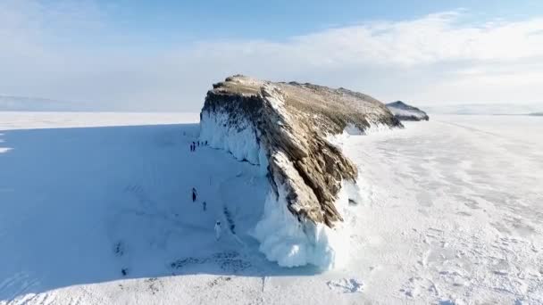 オゴイ島の崖の上にある映画の仏教の仏塔の周りの空中 バイカル湖の冬の凍結氷の地平線 シベリアは印象的な自然の風景です 権力の儀式の場だ 観光ルート — ストック動画