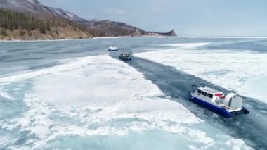A group of tourists goes to Khivus in winter on the ice of Lake Baikal. Russian Winter. Russia, Irkutsk region. February 14, 2021