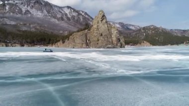 A group of tourists goes to Khivus in winter on the ice of Lake Baikal. Russian Winter. Russia, Irkutsk region. February 14, 2021