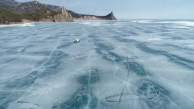 A group of tourists goes to Khivus in winter on the ice of Lake Baikal. Russian Winter. Russia, Irkutsk region. February 14, 2021