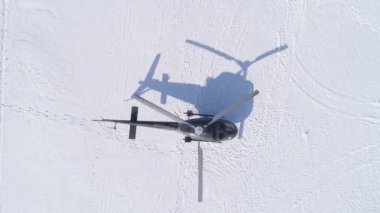 The helicopter stands on the ice of the largest lake Baikal. Black helicopter before takeoff. View from above.