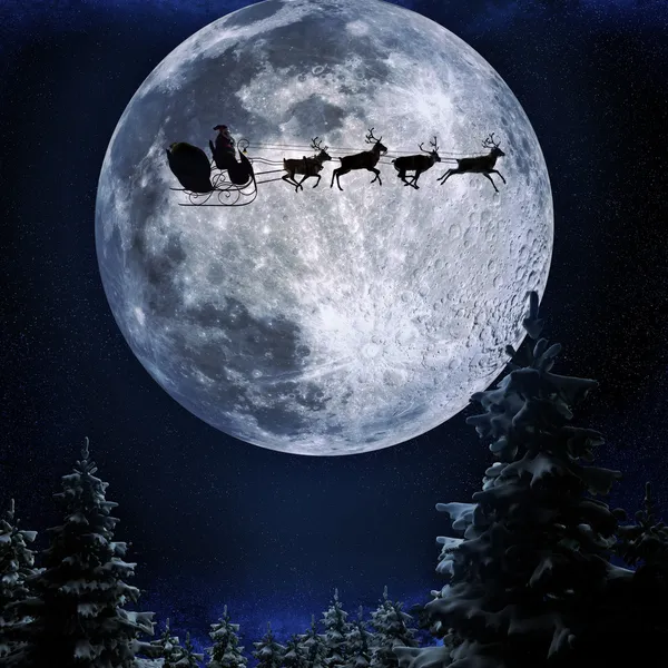 Père Noël volant dans son traîneau sur fond de pleine lune — Photo