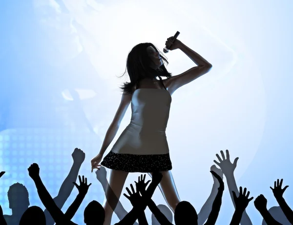 Female singer on stage performing in front of a crowd — Stock Photo, Image