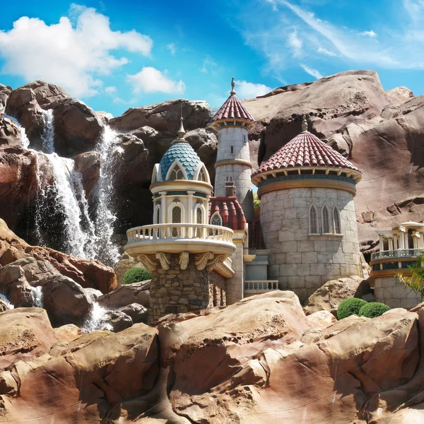 Fantasie kasteel op de rotsen met een waterval achtergrond. — Stockfoto