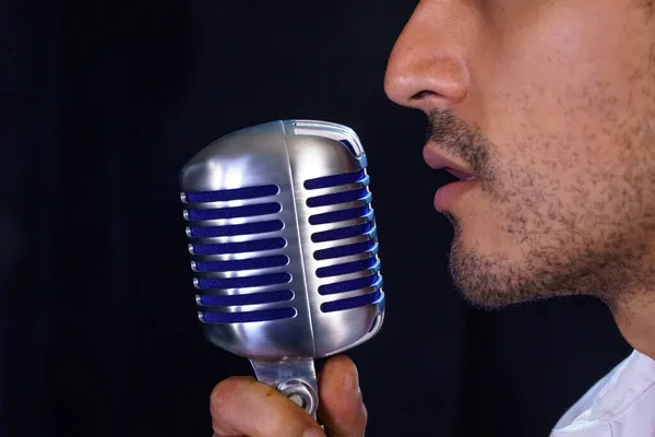 Krøllet Mexicansk Popsanger Synger Med Mikrofon Sort Baggrund - Stock-foto
