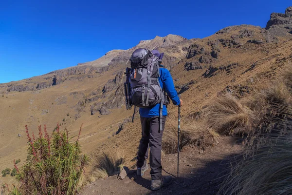 一个人爬上了依萨夏胡特火山群山中的一座小山 — 图库照片
